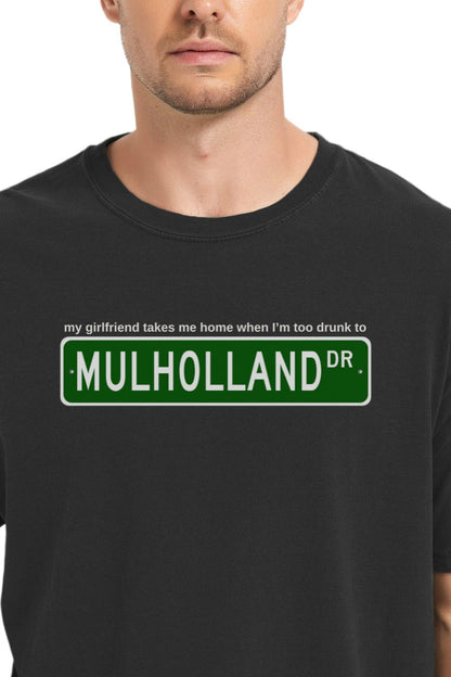 black t-shirt with Mulholland Drive street sign design on a white background, with blink 182 lyrics my girlfriend takes me home when I'm too drunk to drive, worn by a person